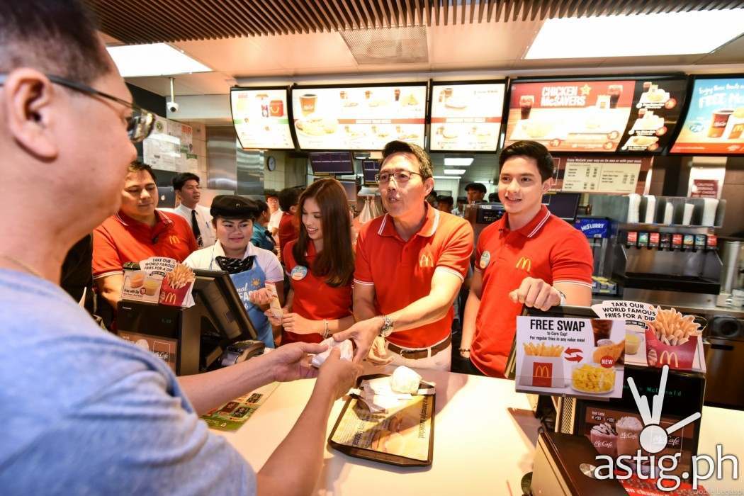 McDonald’s President and Chief Executive Officer Kenneth S. Yang (center) distributed free McMuffin sandwiches to customers.  Together with him are McDonald’s endorsers Alden Richards and Maine Me