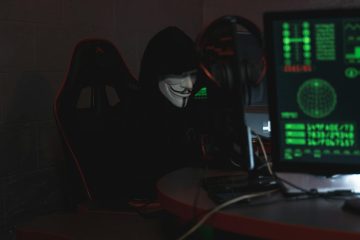 person wearing a mask sitting on chair while using a computer